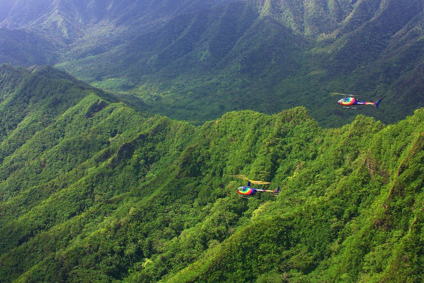 rainbow helicopters flying above oahus mountains